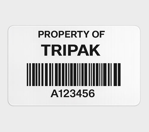 Asset Equipment Labels A roll of white labels with a printed label marked "TRIPAK" detailing part, description, lot, and quantity alongside a QR code and barcode.