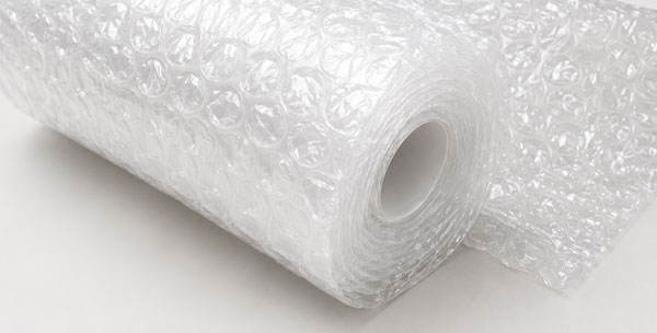 Durable Construction Bubble Wrap A roll of clear bubble wrap with a visible inner core on a flat surface.