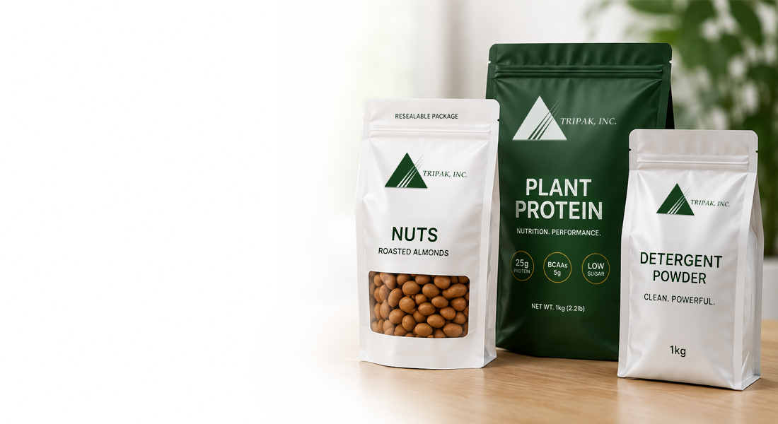 Three packages on a wooden surface: roasted almonds, plant protein, and detergent powder, with the "TRIPAK, INC." logo.